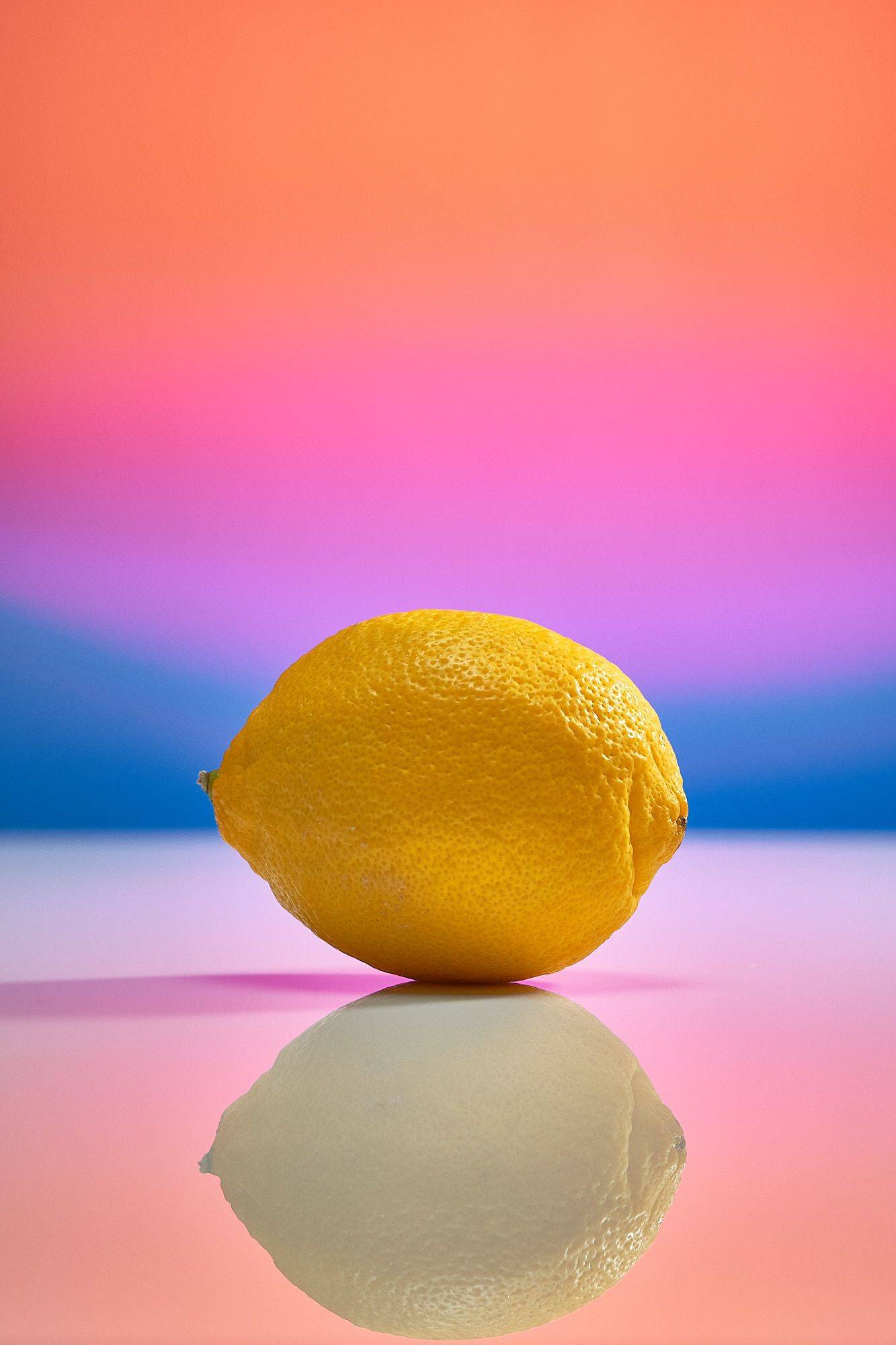 a fresh lemon on rainbow colored background