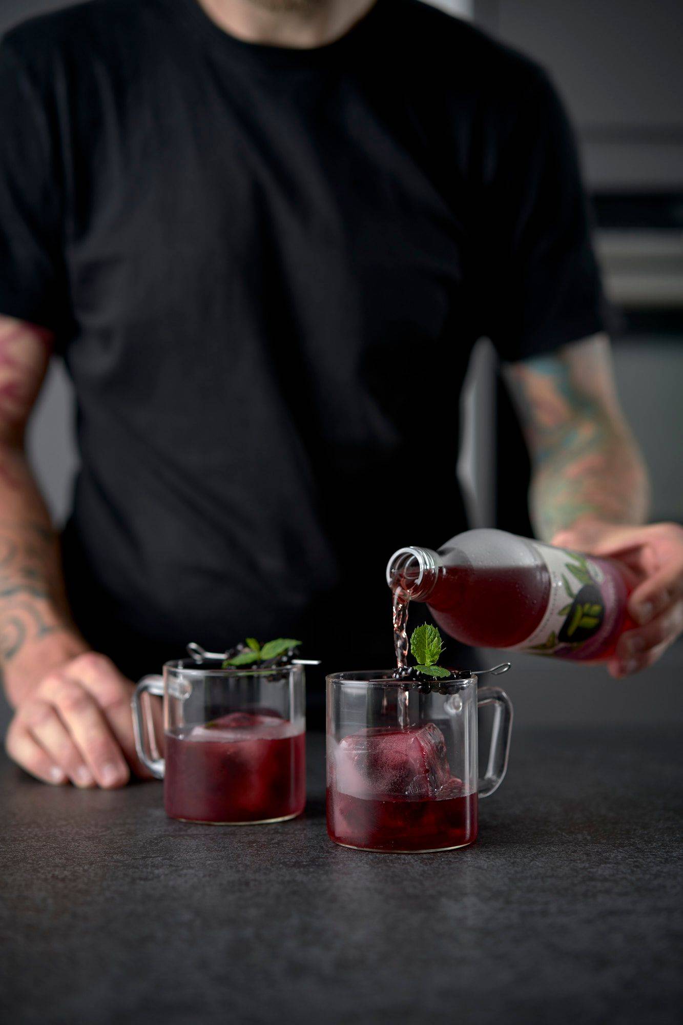 pouring ti refreshing tea blackberry-mint in home kitchen