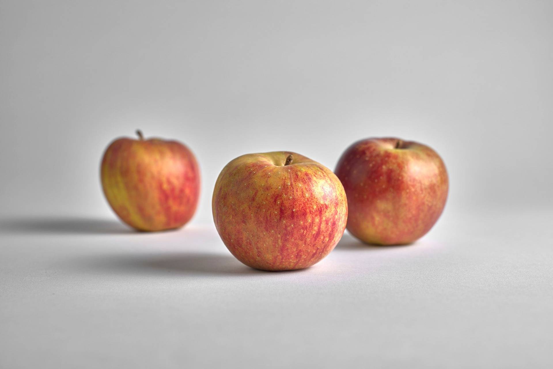 three red apples on white background