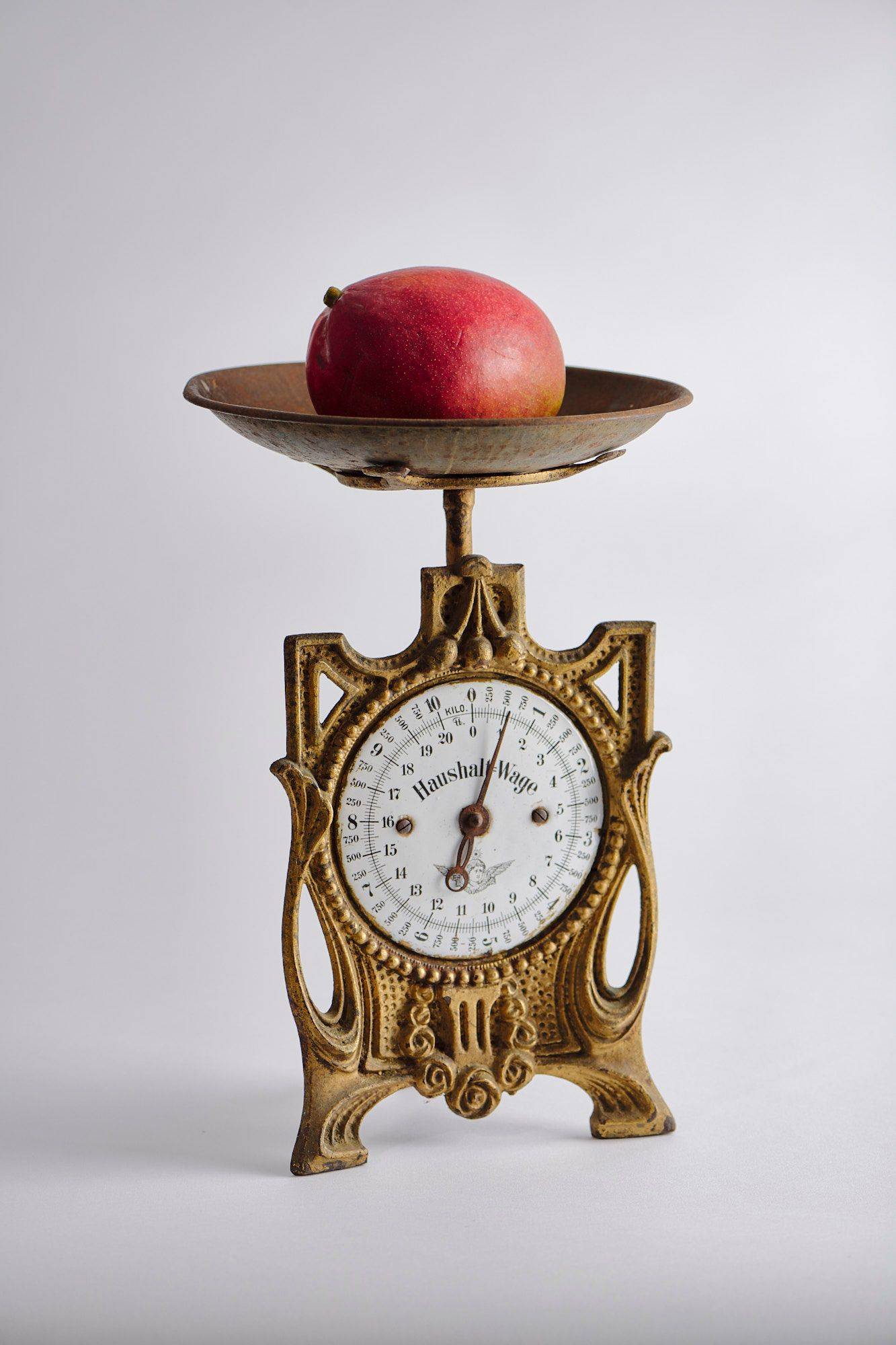 a mango on a vintage scale with white background