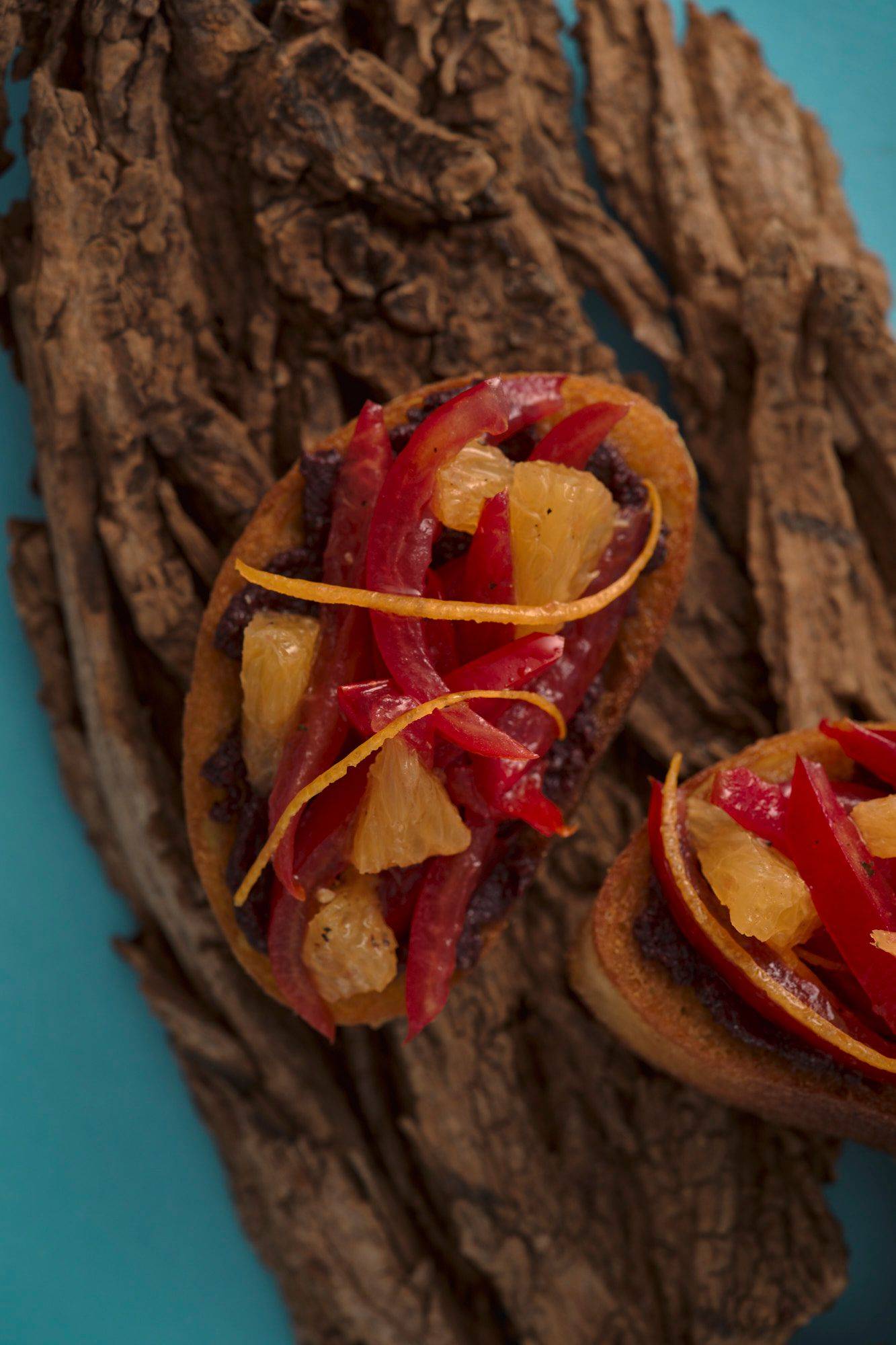 bruschetta-mit-tomate-und-orange bruschetta mit tomate und orange auf blauem hintergrund