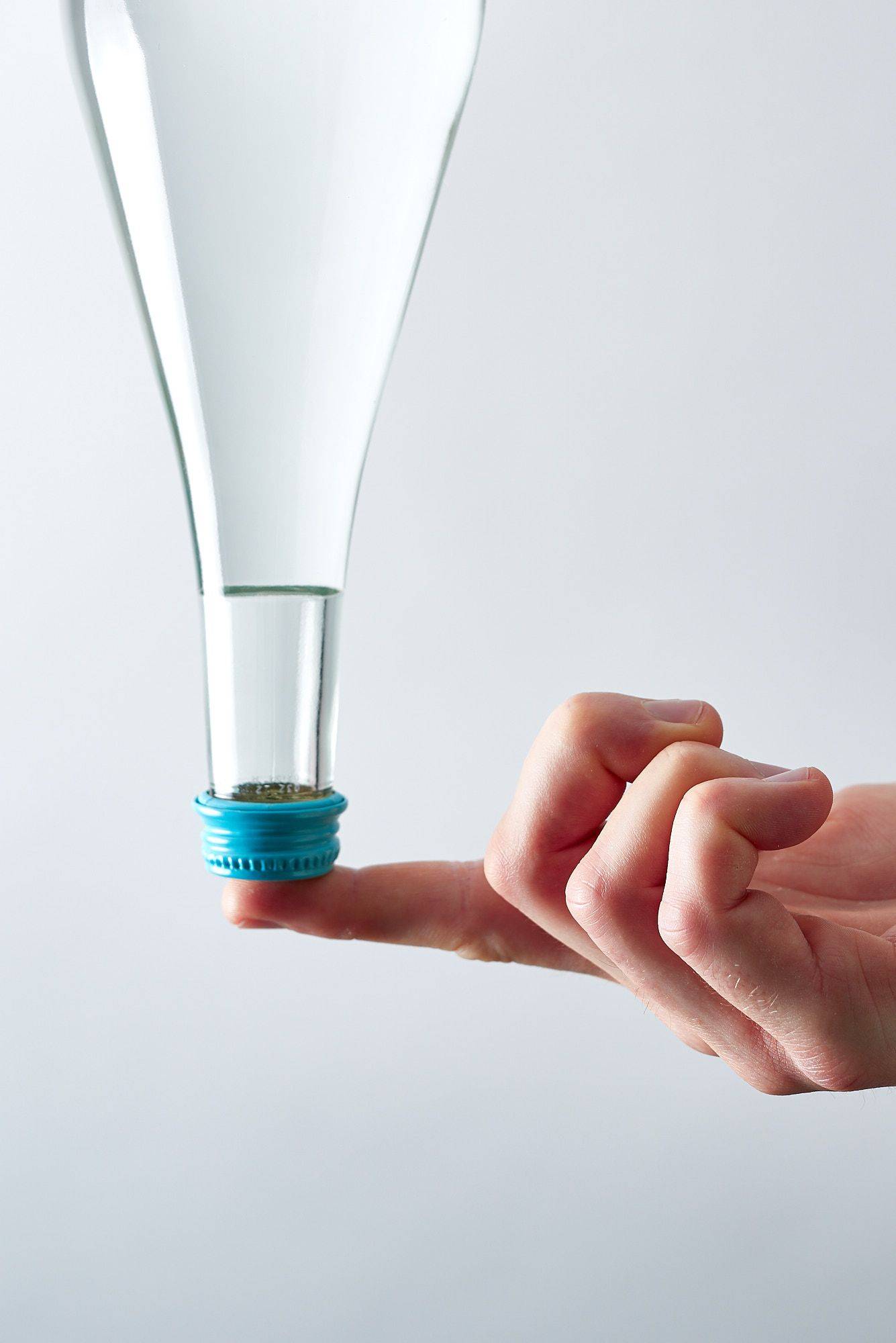 mineral water bottle on finger tip with white background