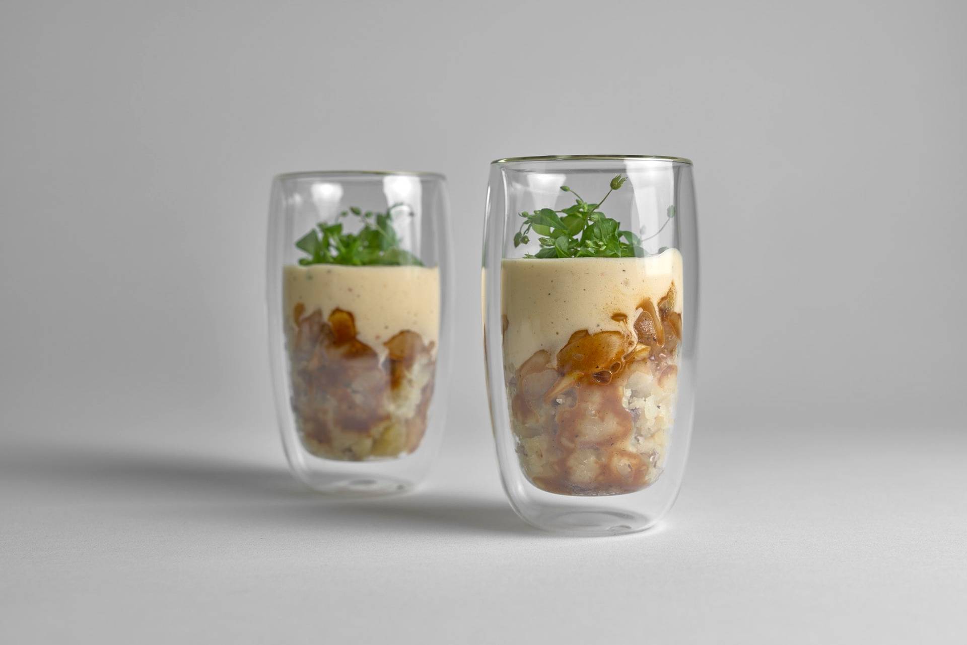 zwei gläser spargel cappuccino mit kartoffel stampf, veganer jus und apfel sauce hollandaise