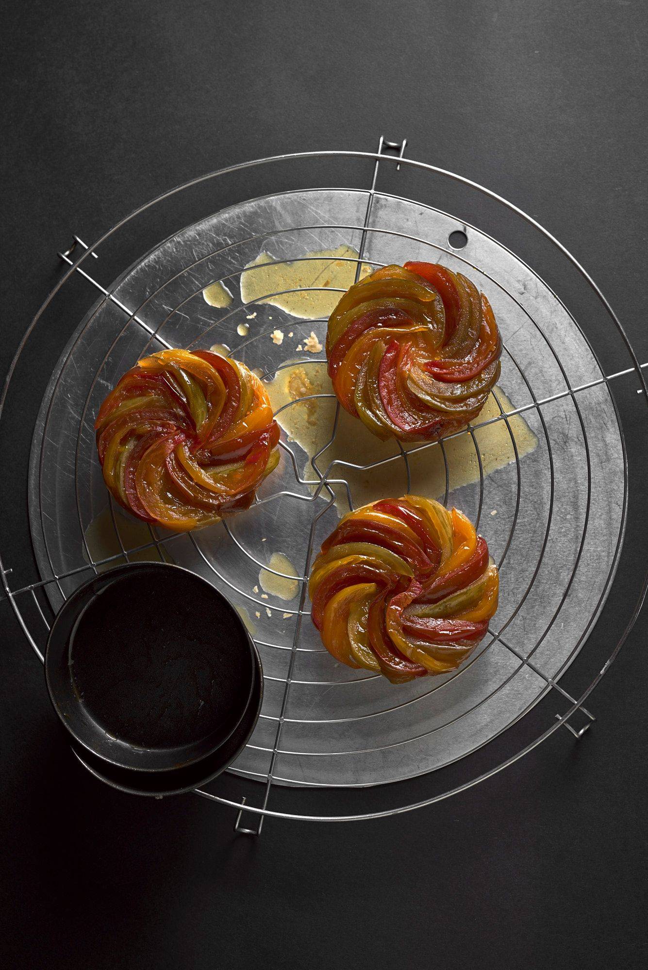 baked-tomato-tarte-tatin three freshly baked tomato tarte tatins on a baking grid with black background