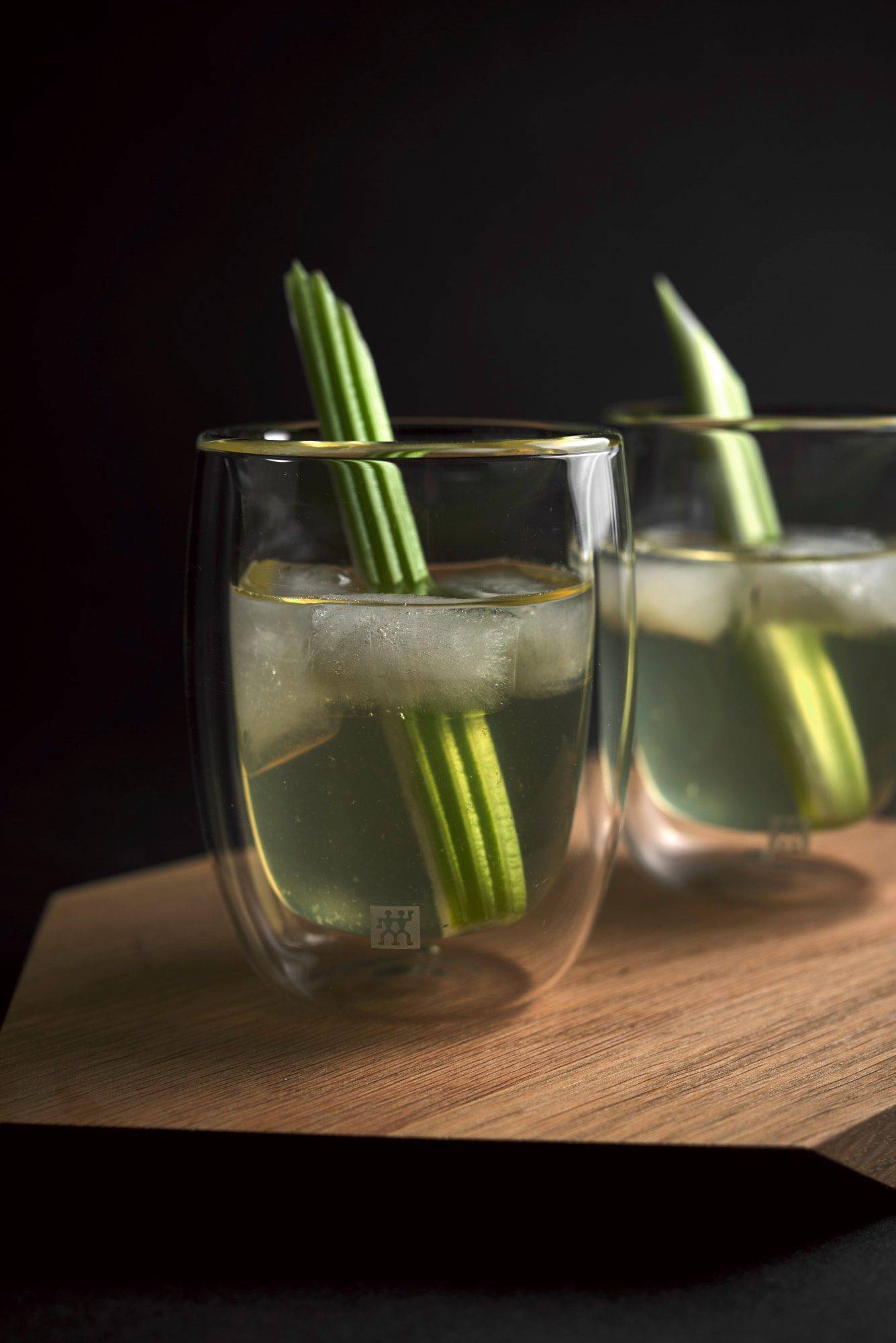 two glasses of white bloody mary on a wooden tray with black background