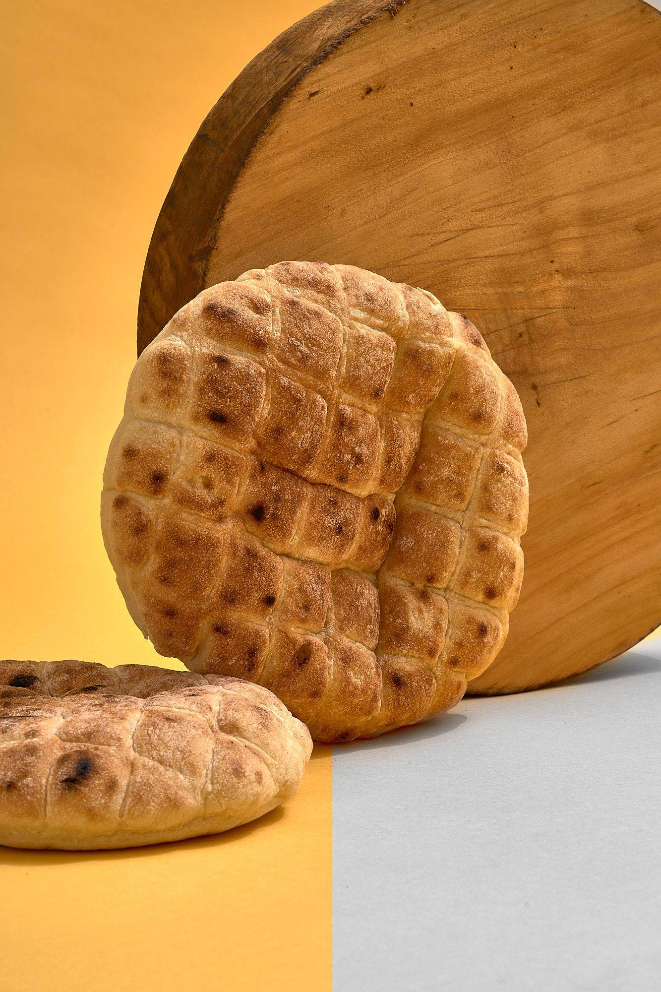 pita bread with wooden board on yellow background