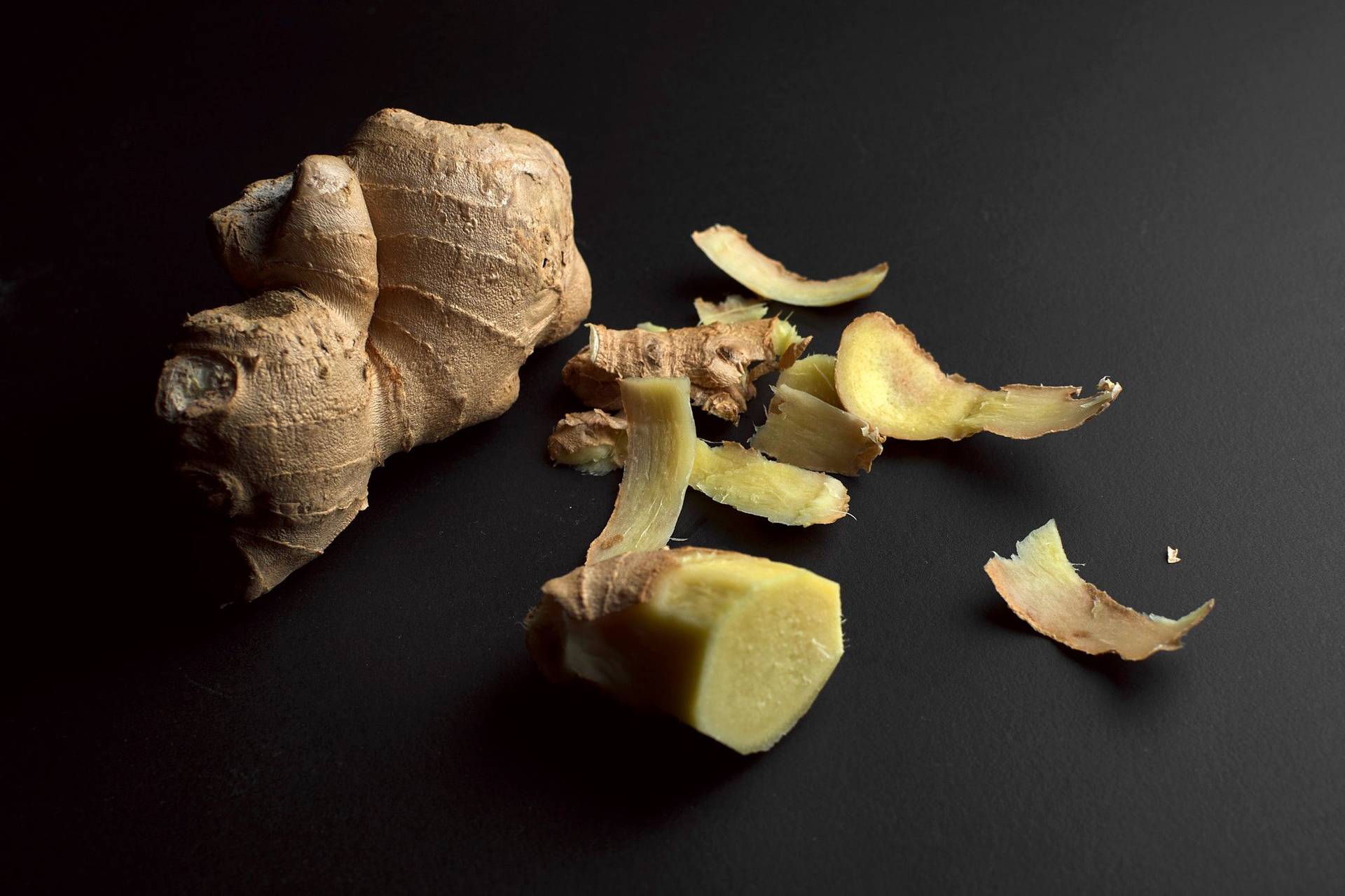 peeled ginger on black background