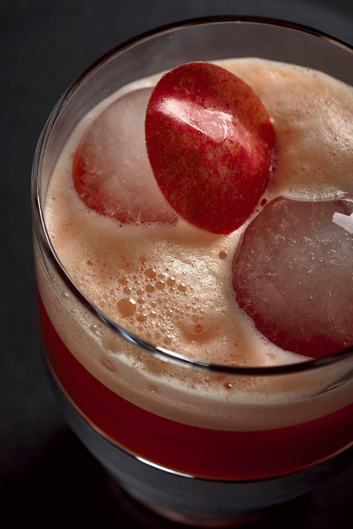 smoky bell pepper whiskey sour cocktail on black background