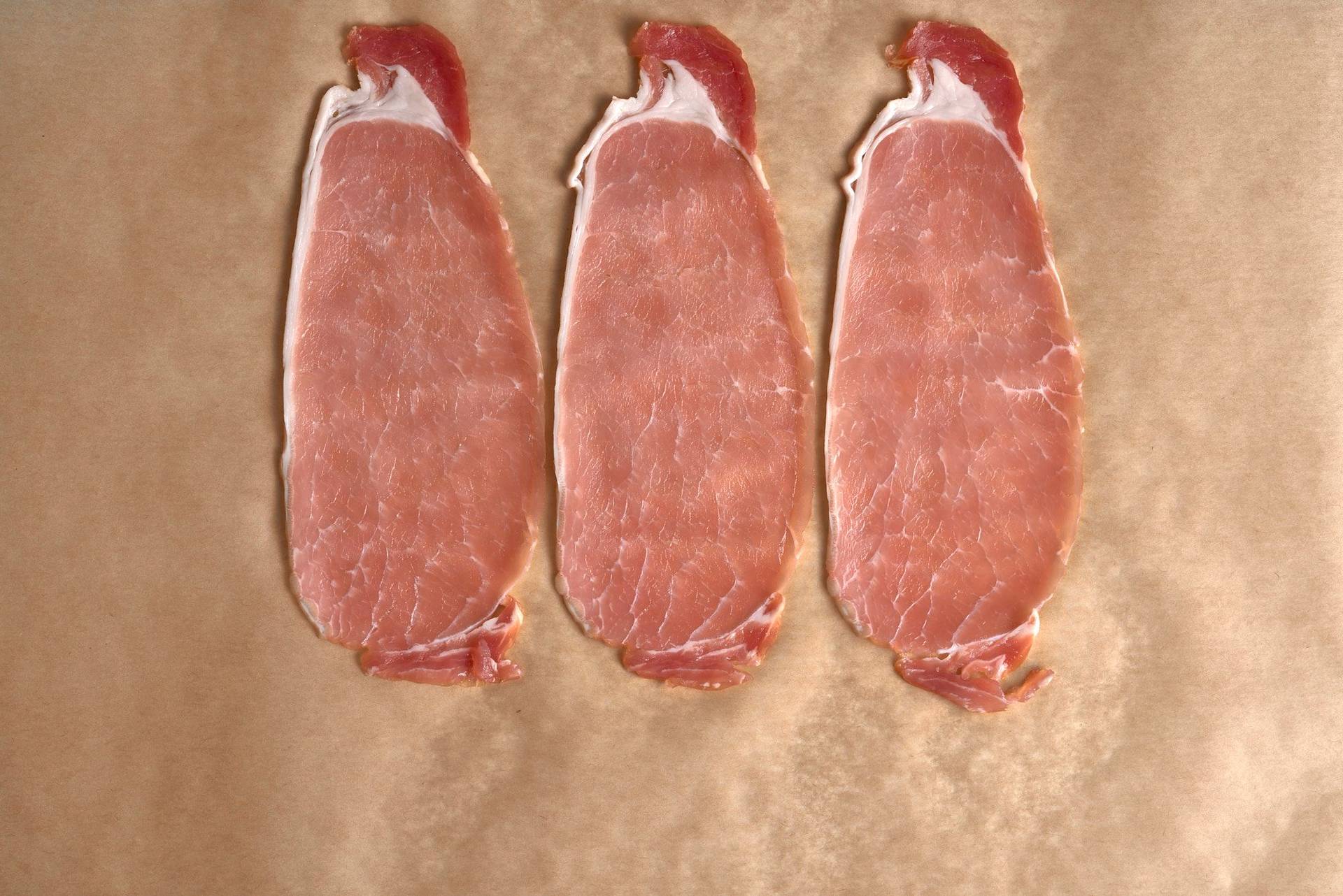 three slices of bacon on a baking sheet