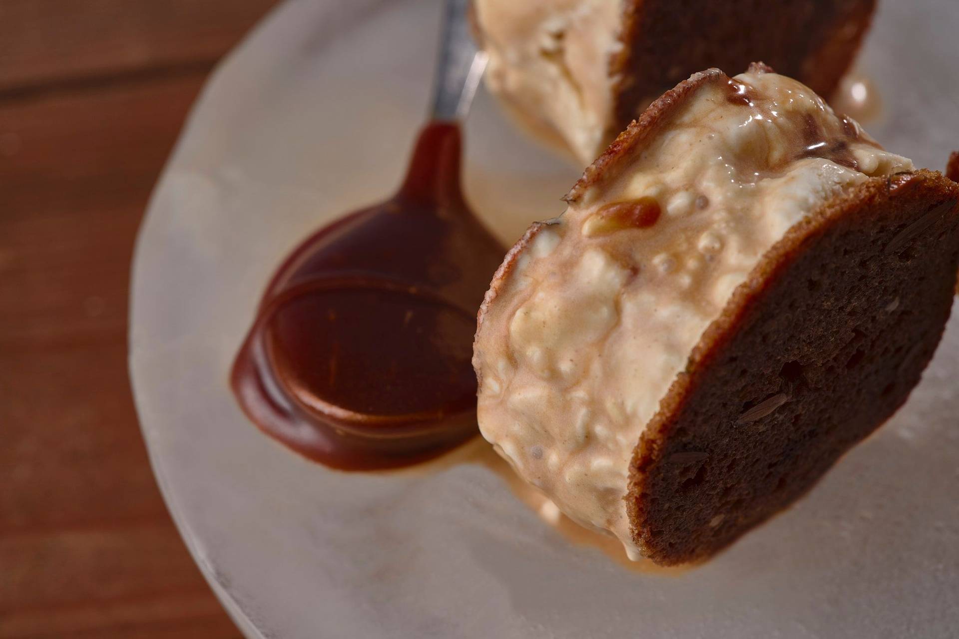 sourdough-ice-cream-sandwich-with-salted-caramel sourdough ice cream sandwich with salted caramel on an ice plate with wooden table