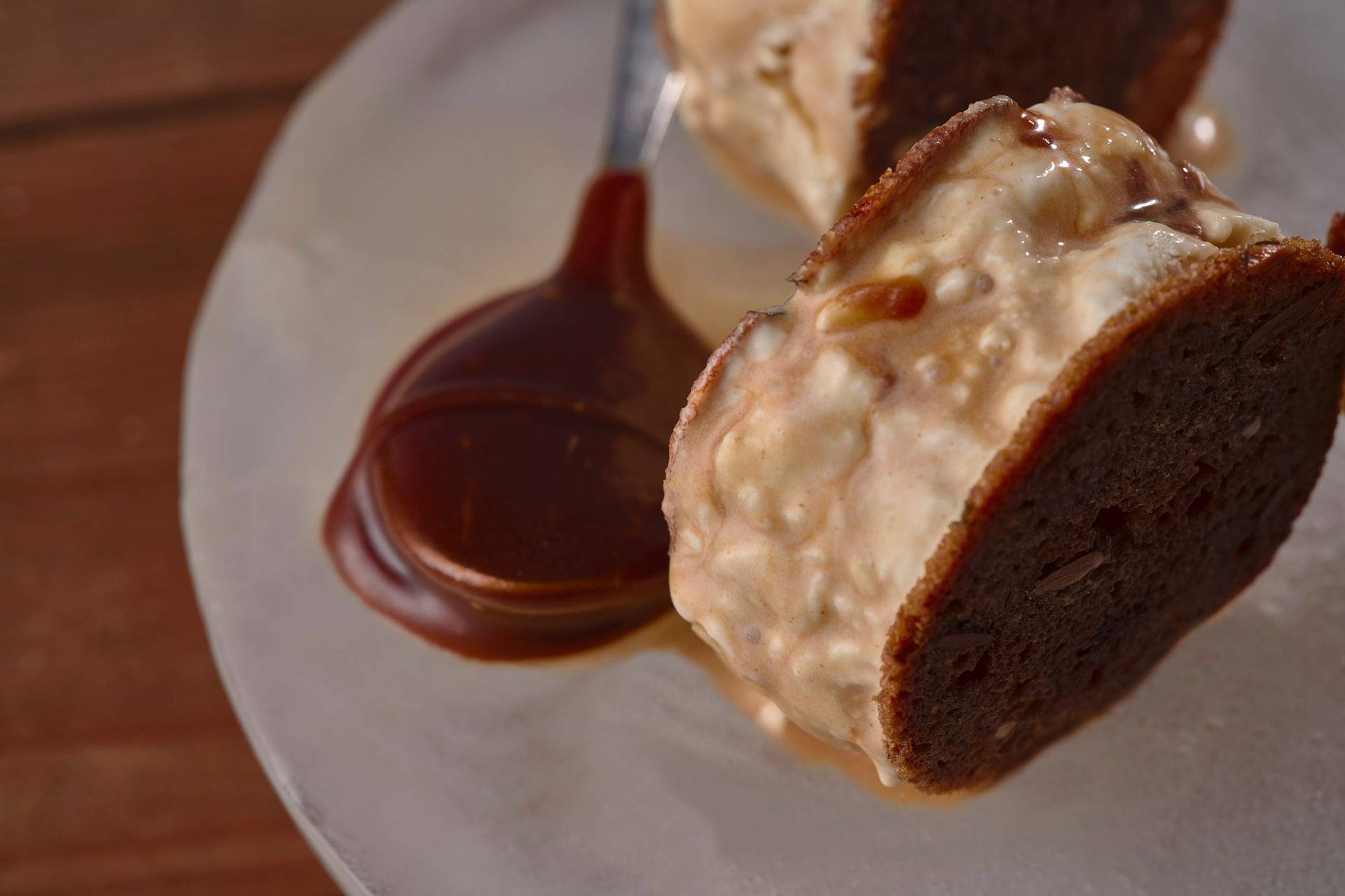 sourdough ice cream sandwich with salted caramel on an ice plate with wooden table