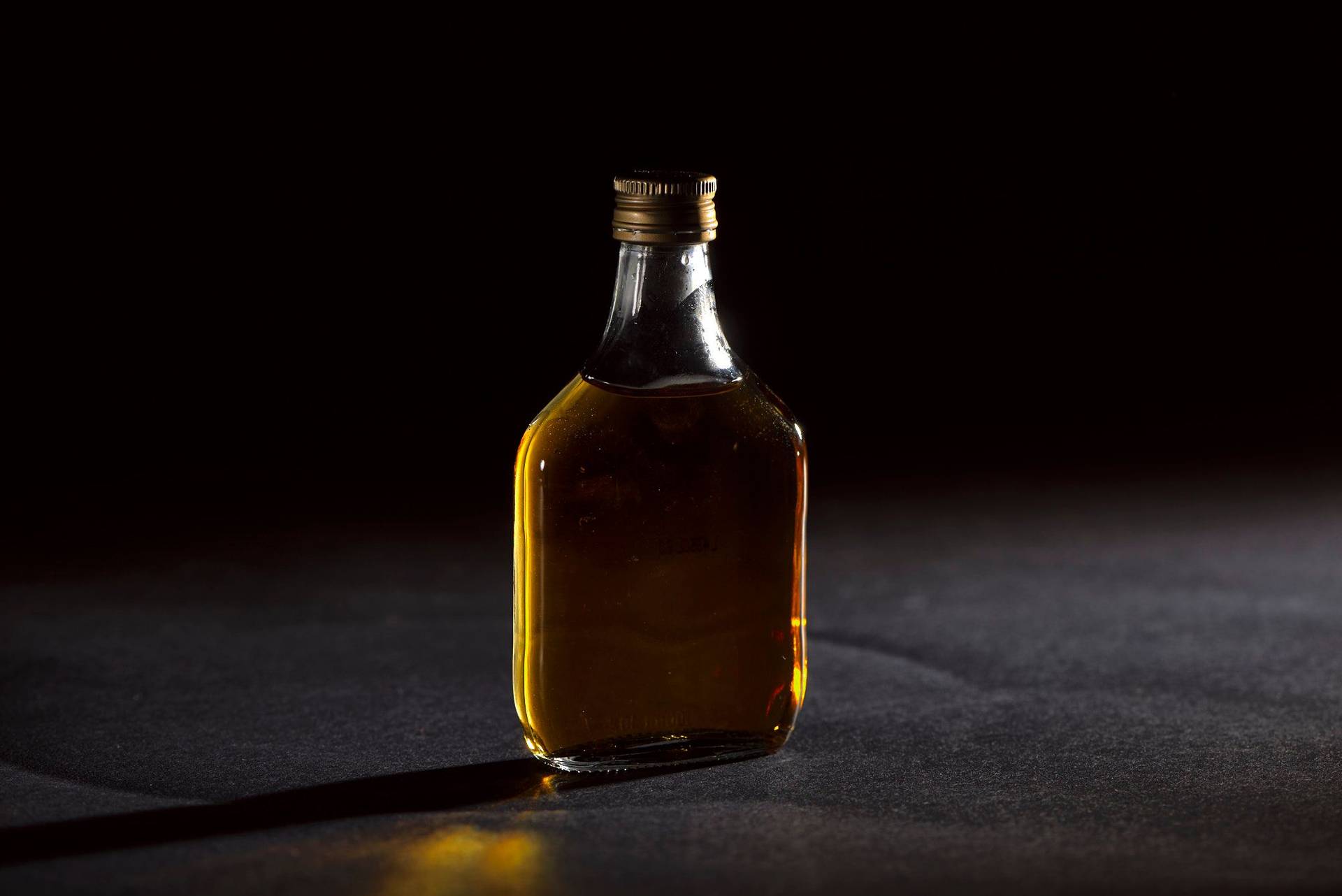 a small bottle of whiskey on black background