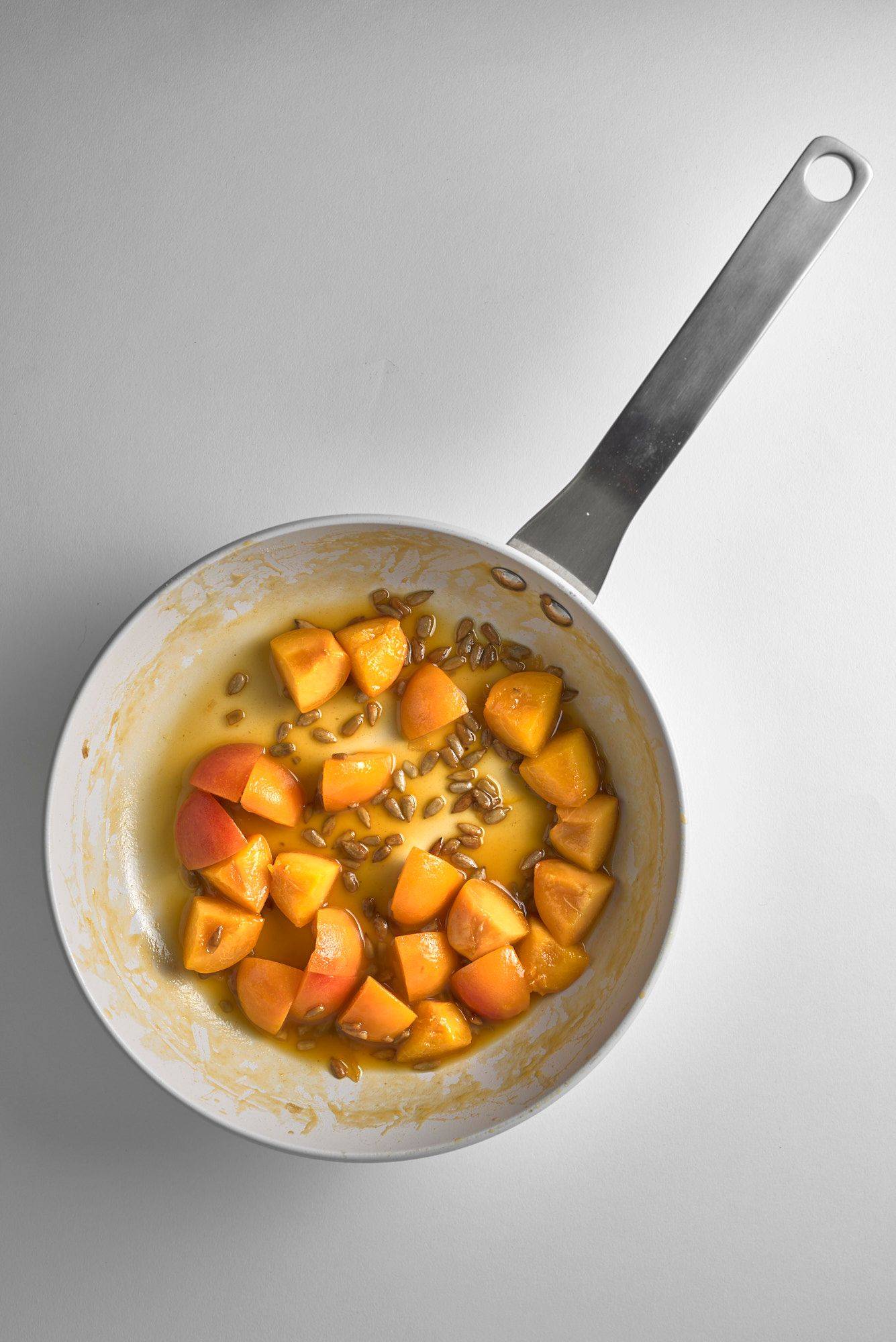 caramelized apricots with sunflower seeds on white background