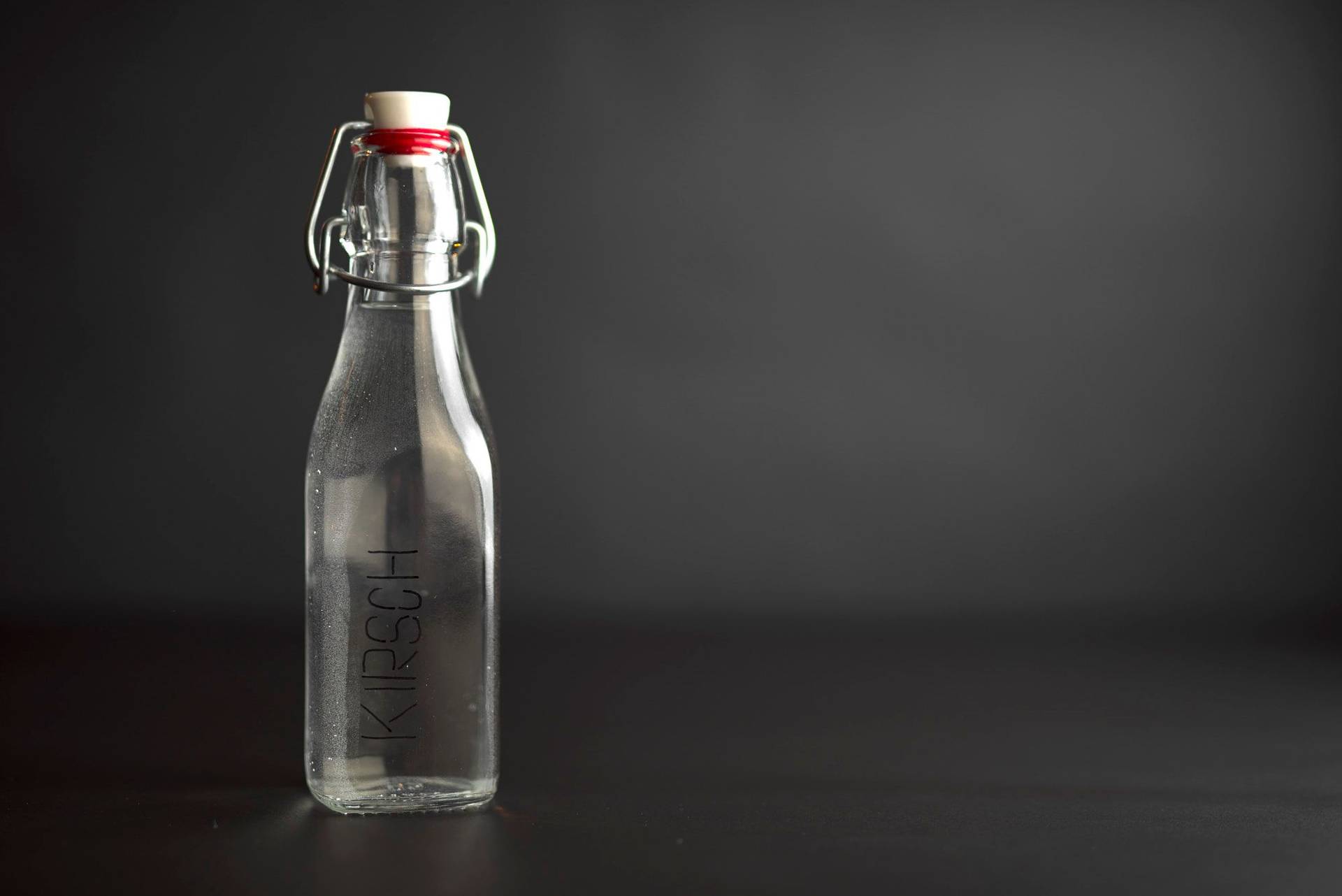 kirsch liquor in a glass bottle with black background