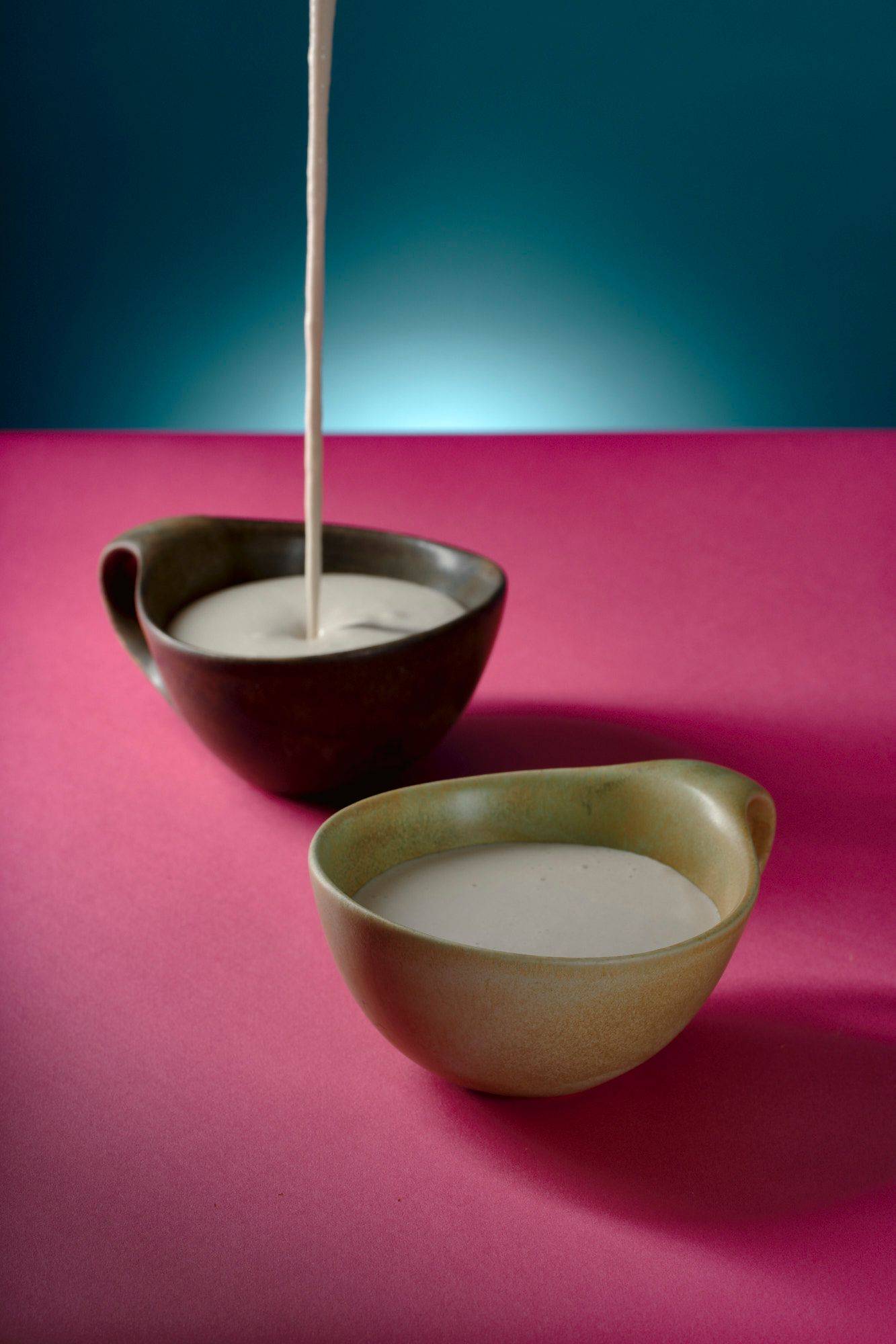 sunflower seed cream in ceramic cups with pink and blue background