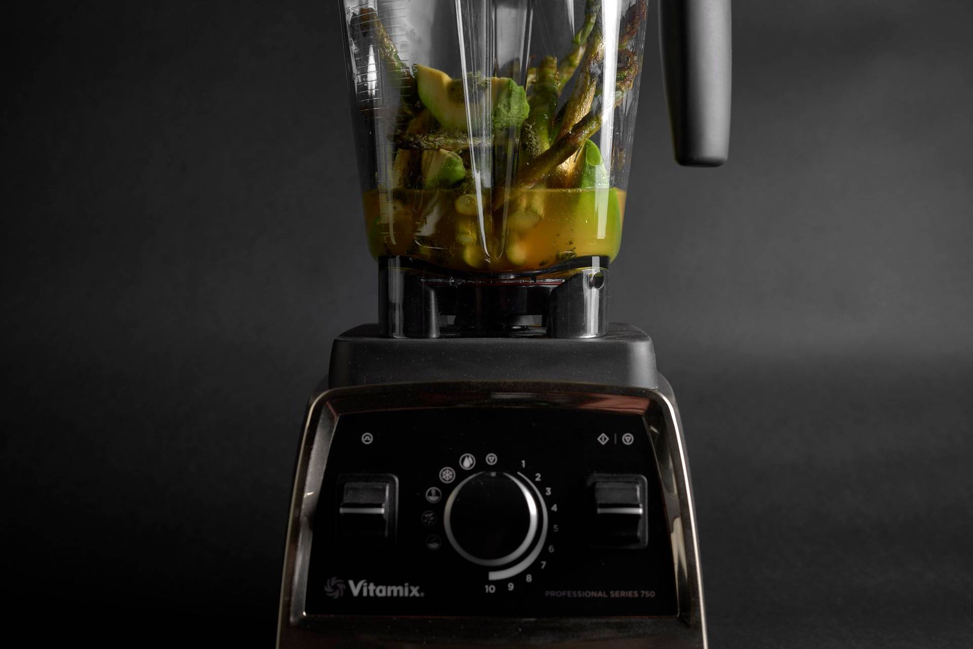 making asparagus-matcha sauce in a kitchen blender with black background