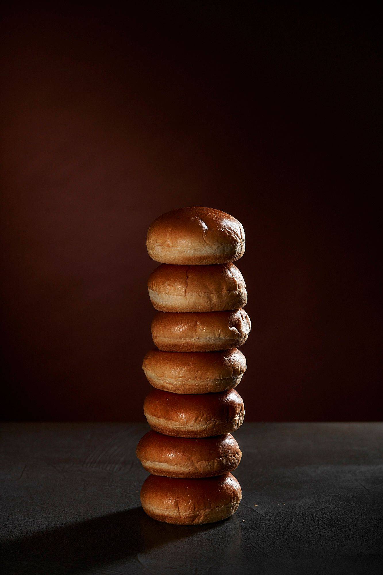 a stack of brioche buns with brown background