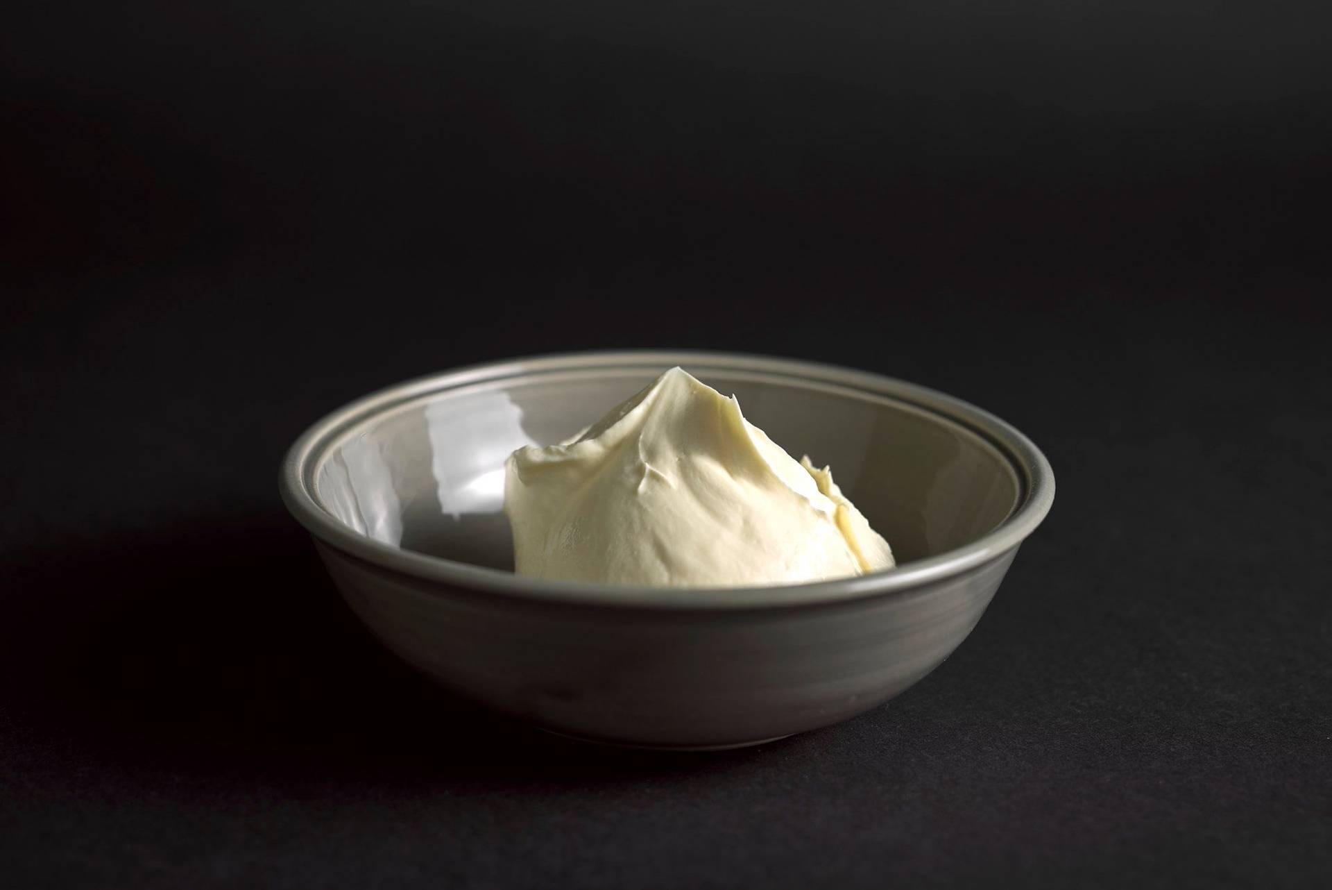 creme fraiche in einer grauen schale mit schwarzem hintergrund