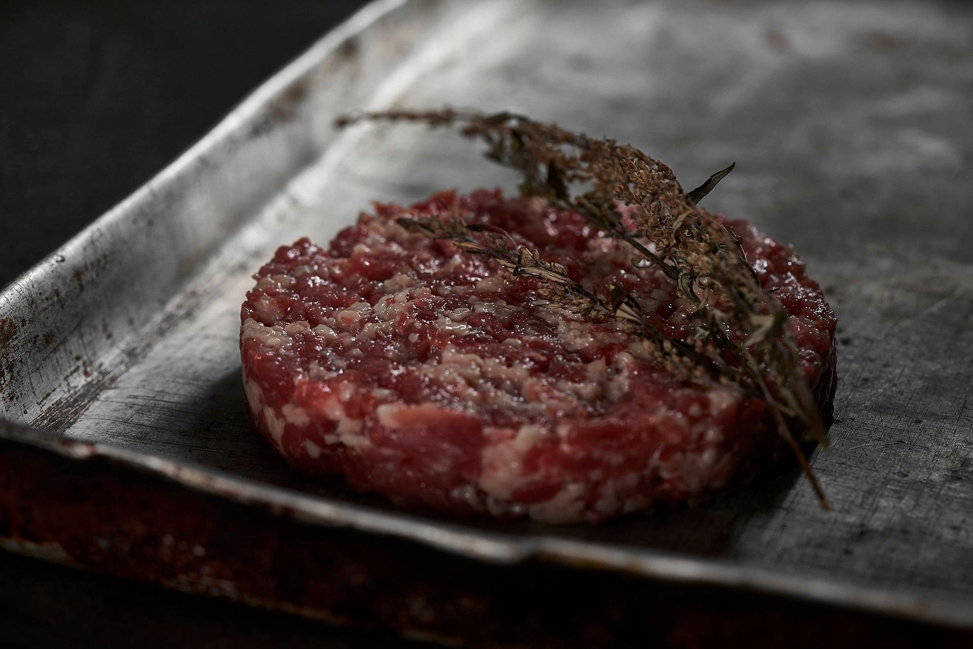 rohes burger patty aus gans auf vintage blech