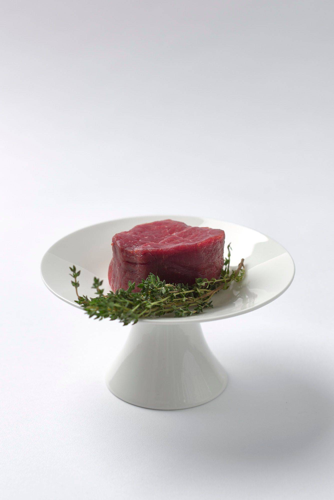 a piece of beef tenderloin steak with white background