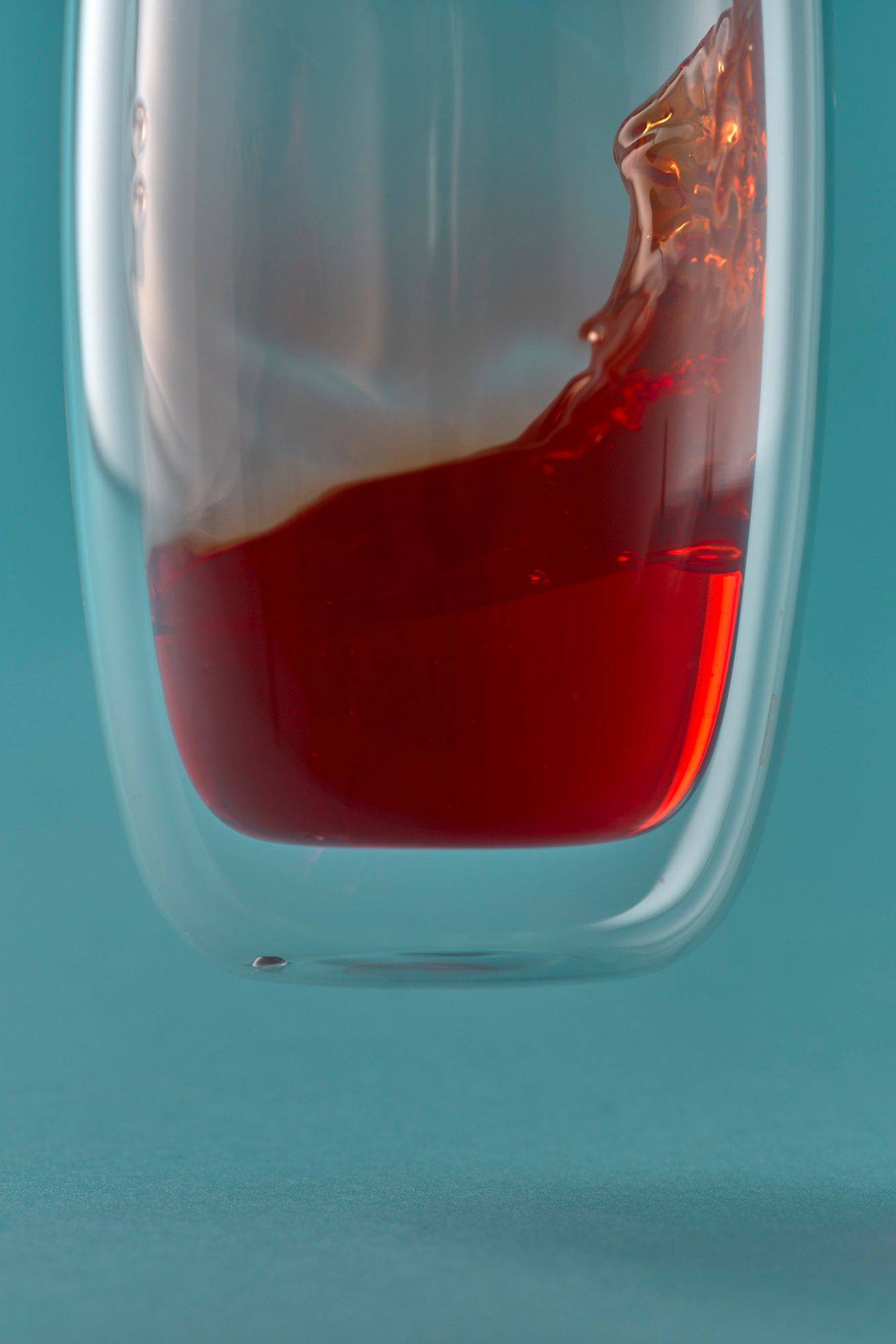 campari-und-aperol ein glas mit campari und aperol auf blauem hintergrund