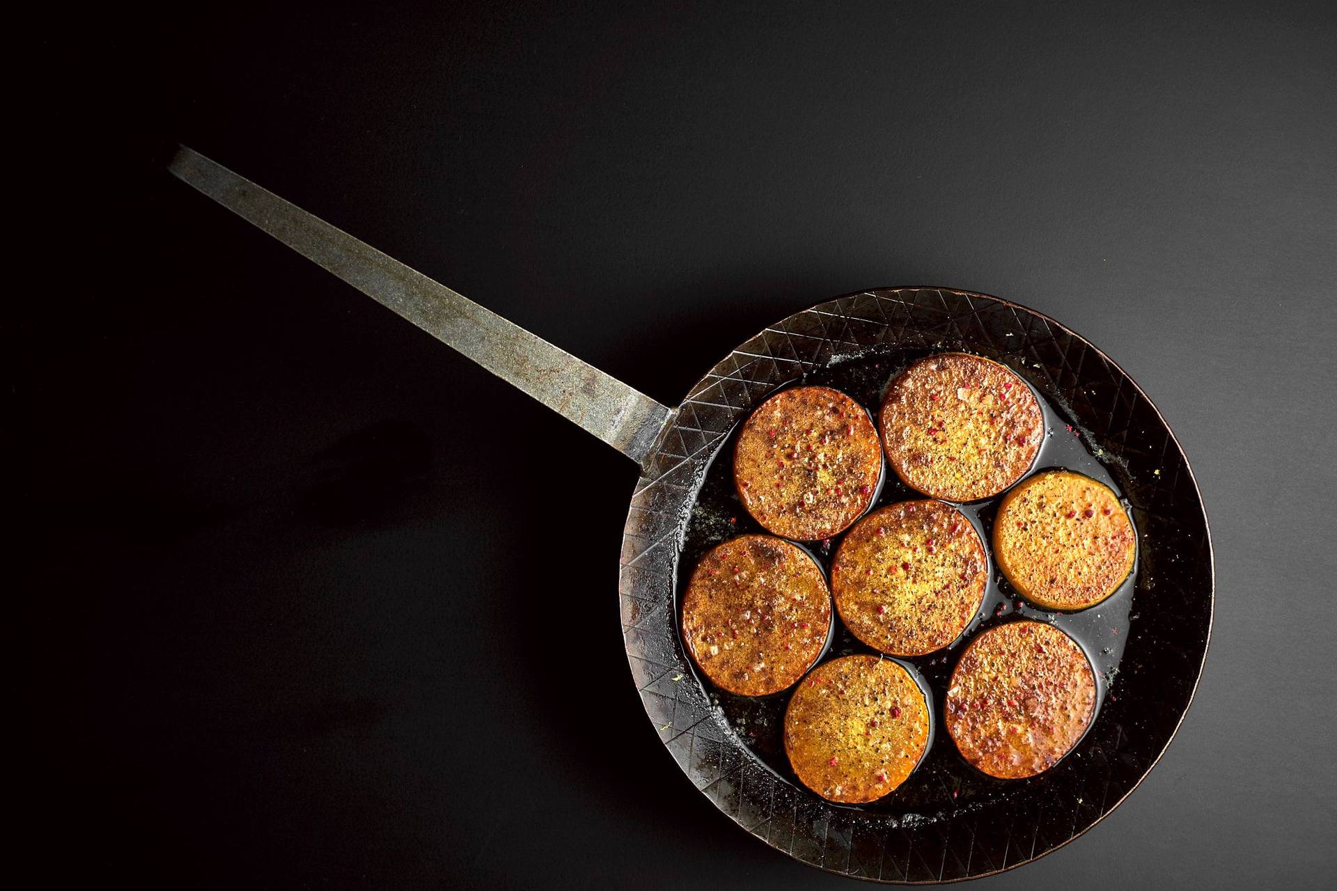 roasted pumpkin in a cast iron pan with black background