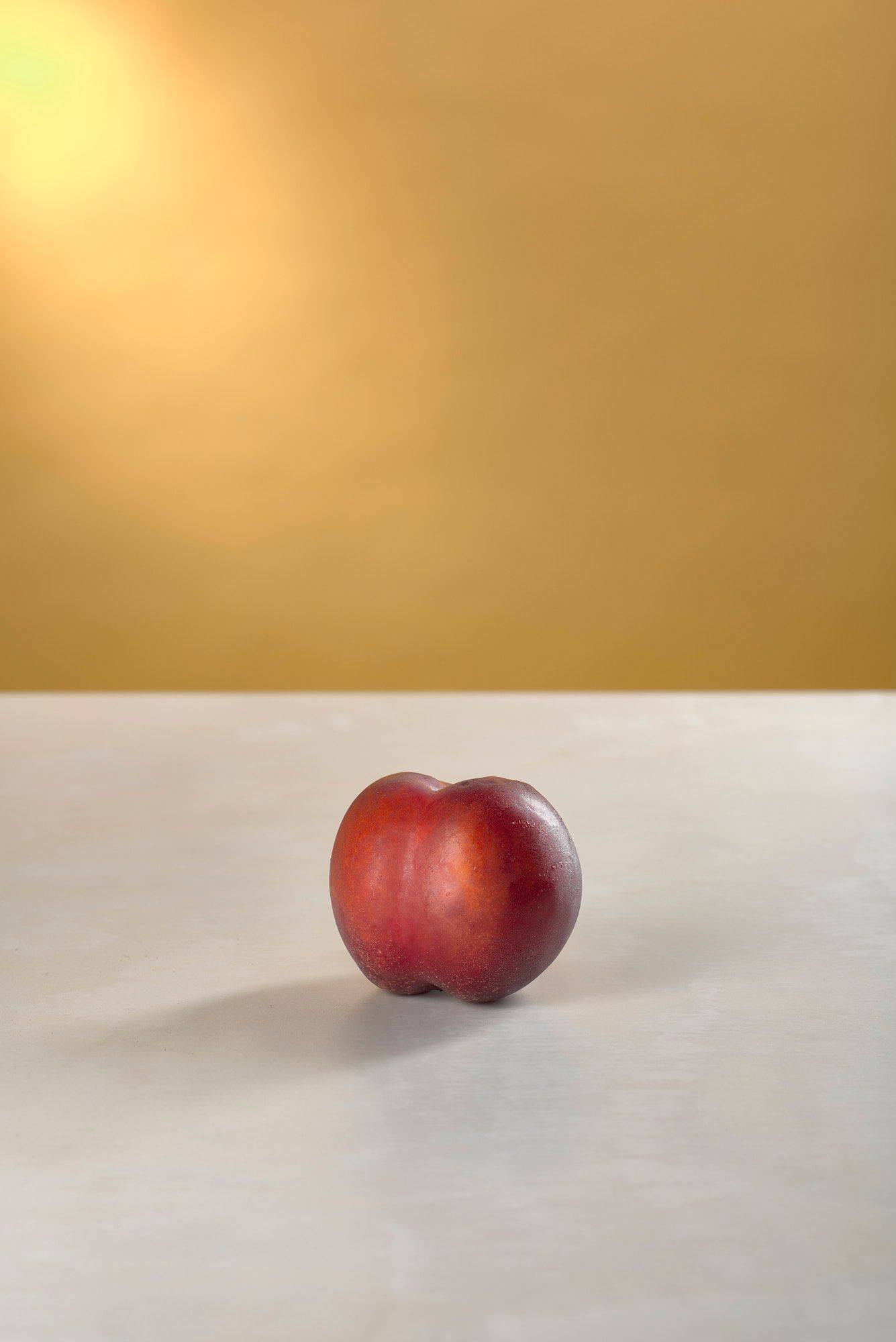 a nectarine on white sapienstone top with yellow background