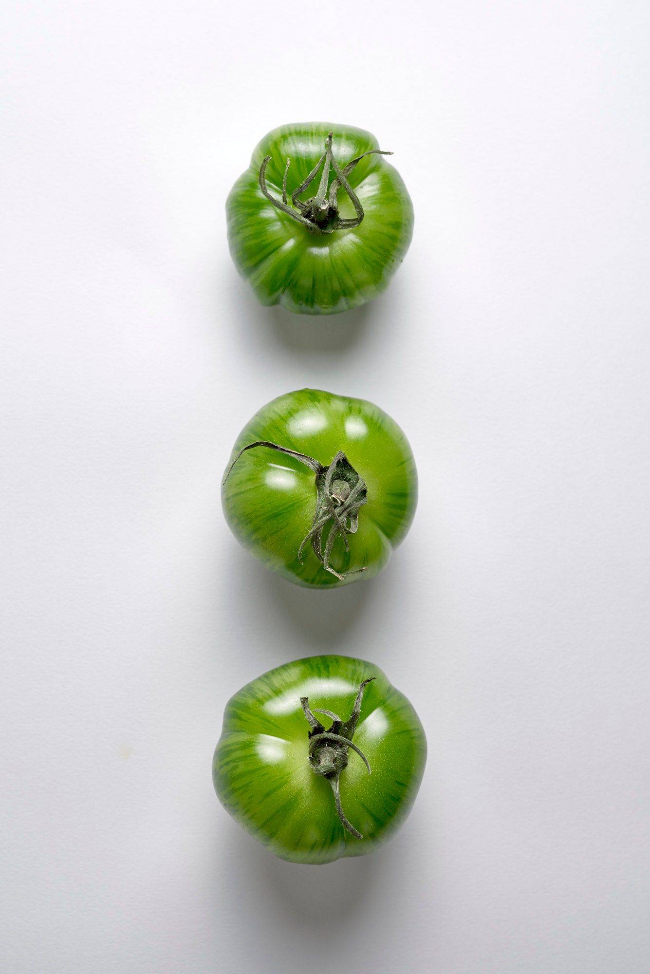 tomatoes three green tomatoes on white background