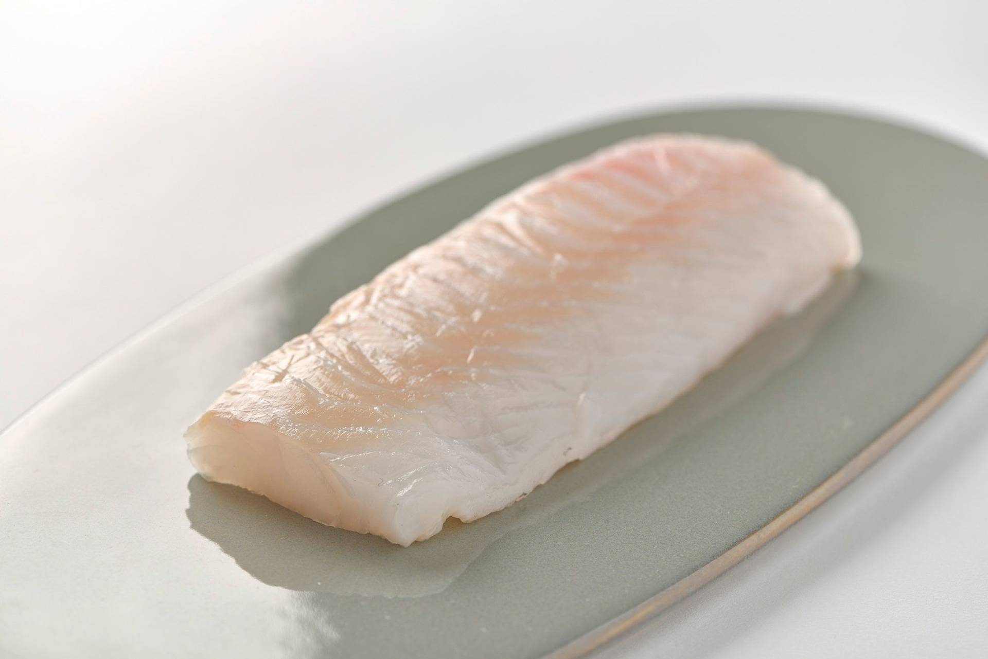 cod fillet on a gray plate with white background