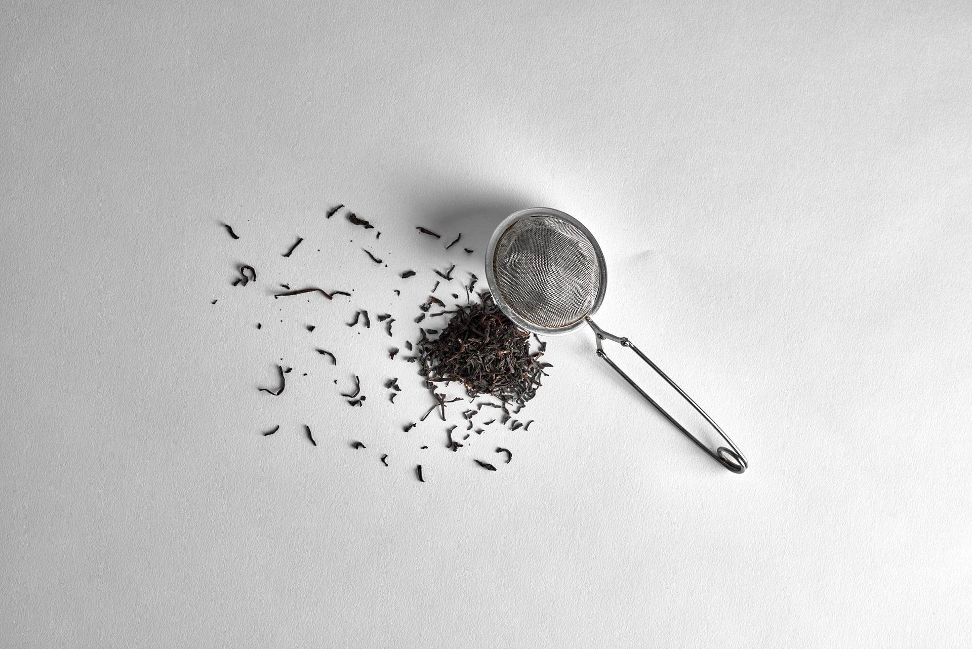 tea and a sieve on white background