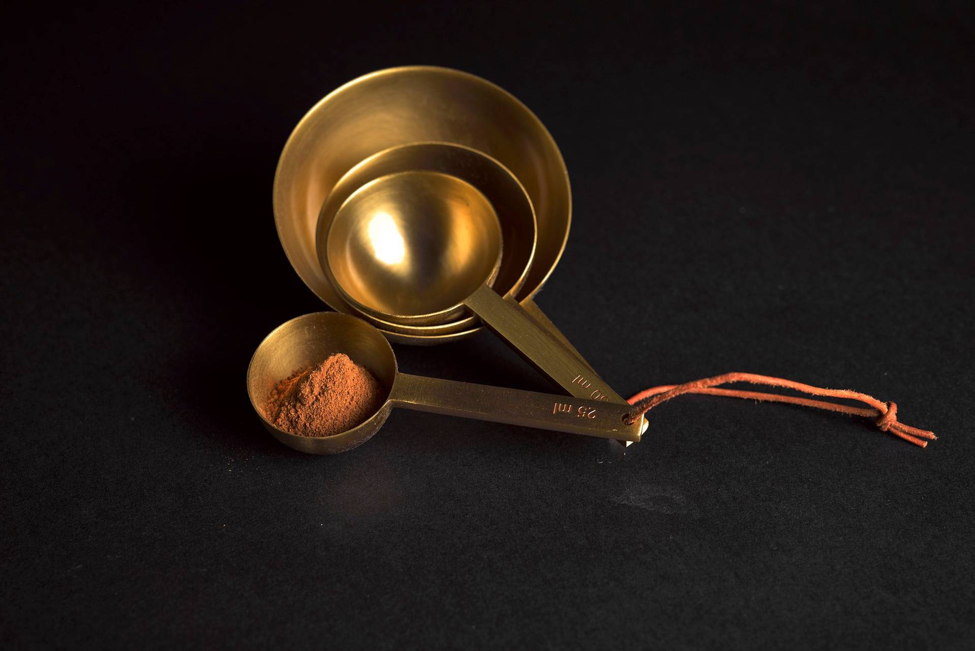 cinnamon powder in a brass measuring spoon on a sapienstone top