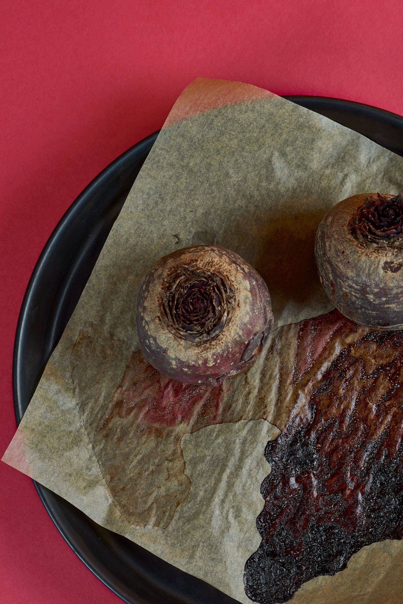 baked beets in a baking pan with red background
