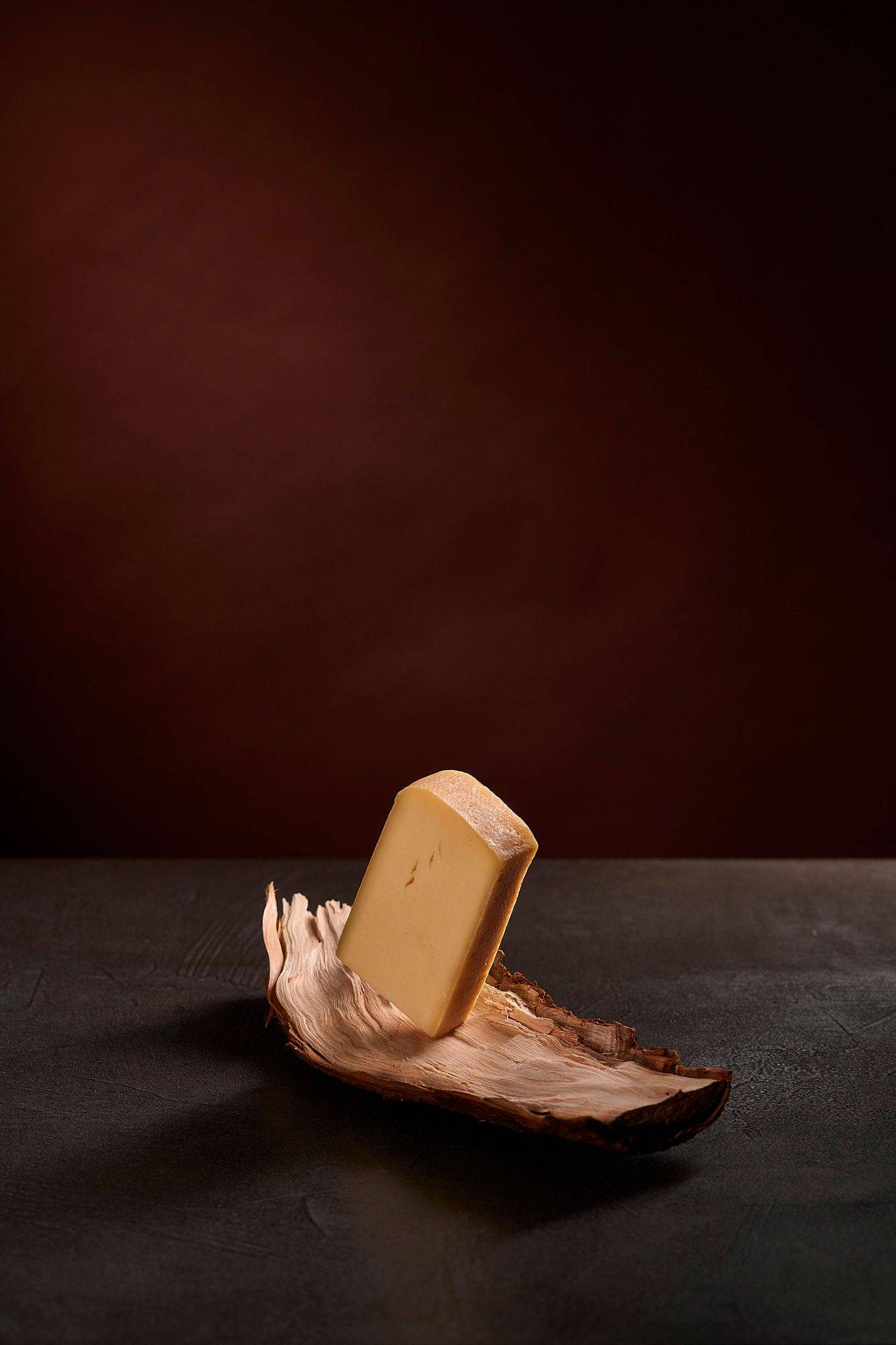 raclette cheese on wood with brown background